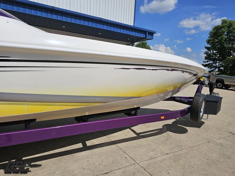 Slide: The Image of 2003 Sunsation 32 Dominator boat on a purple trailer, parked outdoors. - 12
