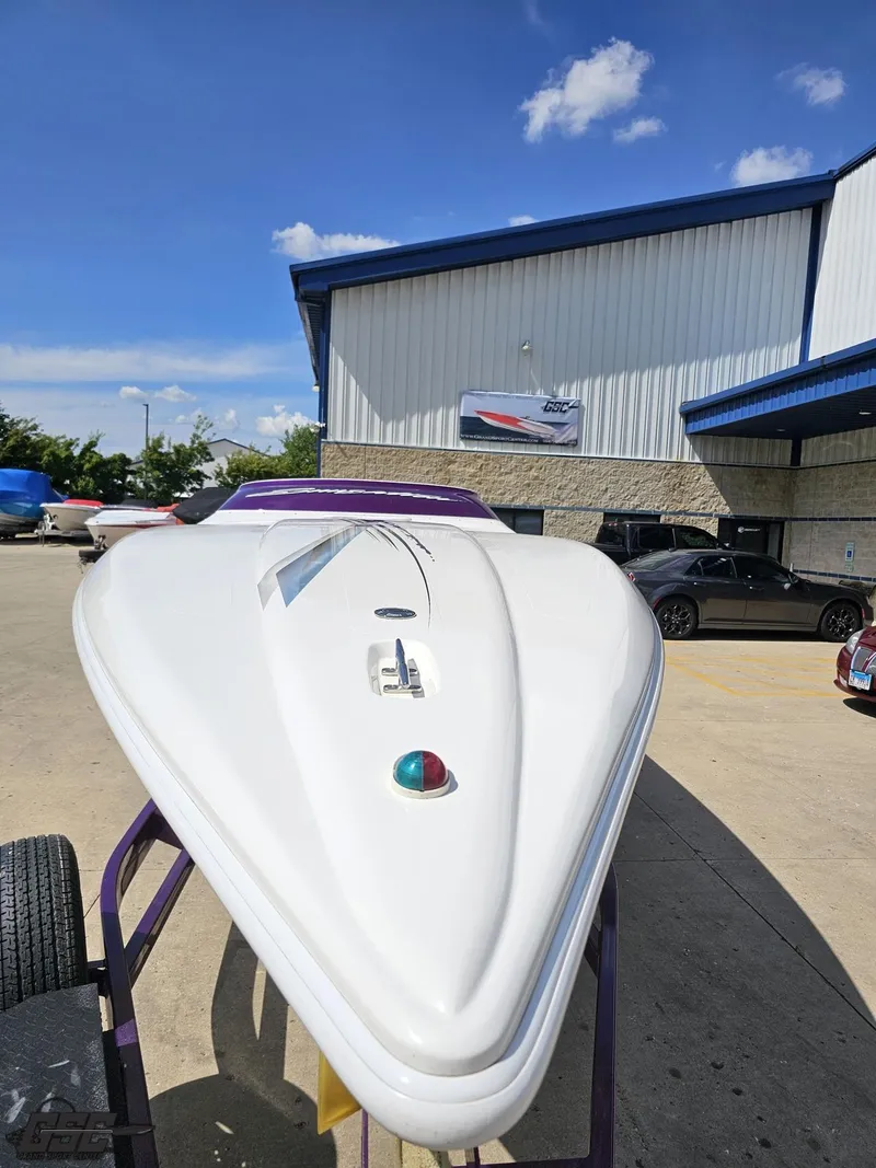 Slide: The Image of 2003 Sunsation 32 Dominator boat displayed outside a building under a clear blue sky. - 14