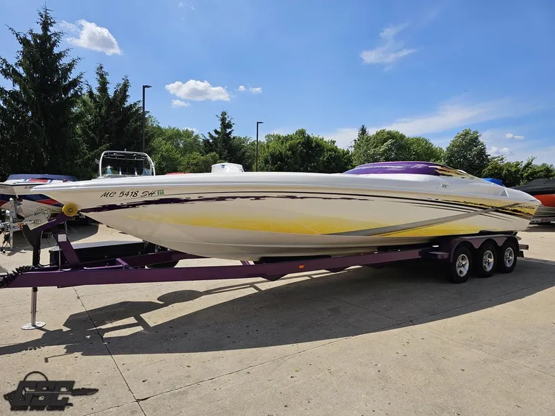 Slide: The Image of 2003 Sunsation 32 Dominator speedboat on trailer, vibrant yellow and purple design, sunny day. - 17