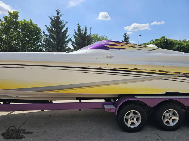 Slide: The Image of 2003 Sunsation 32 Dominator boat with vibrant yellow and purple design on a trailer. - 20