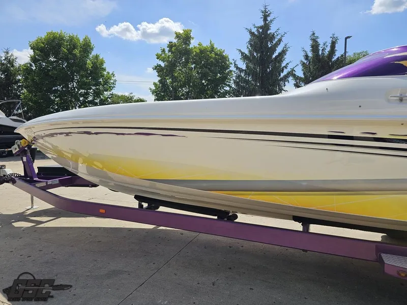 Slide: The Image of 2003 Sunsation 32 Dominator boat on purple trailer under clear blue sky. - 22