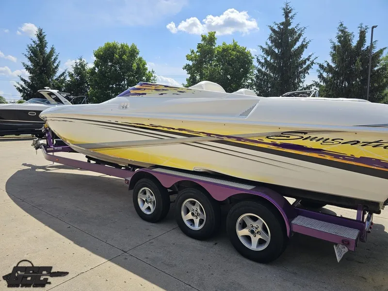 Slide: The Image of 2003 Sunsation 32 Dominator boat on a purple trailer, parked outdoors. - 24