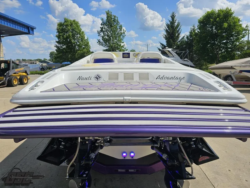 Slide: The Image of 2003 Sunsation 32 Dominator boat with custom "Nauti Advantage" design, docked outdoors. - 31