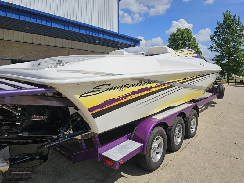 Slide: The Image of 2003 Sunsation 32 Dominator boat on a purple trailer, parked outdoors. - 34