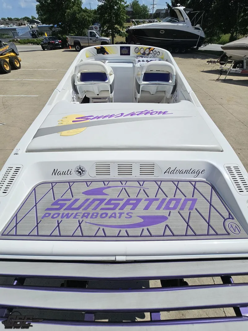 Slide: The Image of 2003 Sunsation 32 Dominator powerboat with custom graphics, docked outdoors. - 39