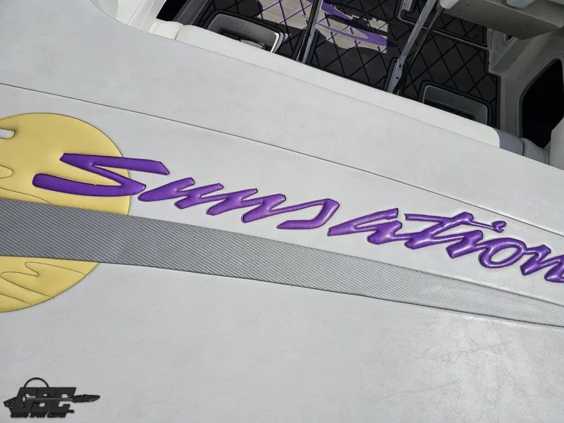 Slide: The Image of 2003 Sunsation 32 Dominator boat interior with purple logo and sun graphic. - 44