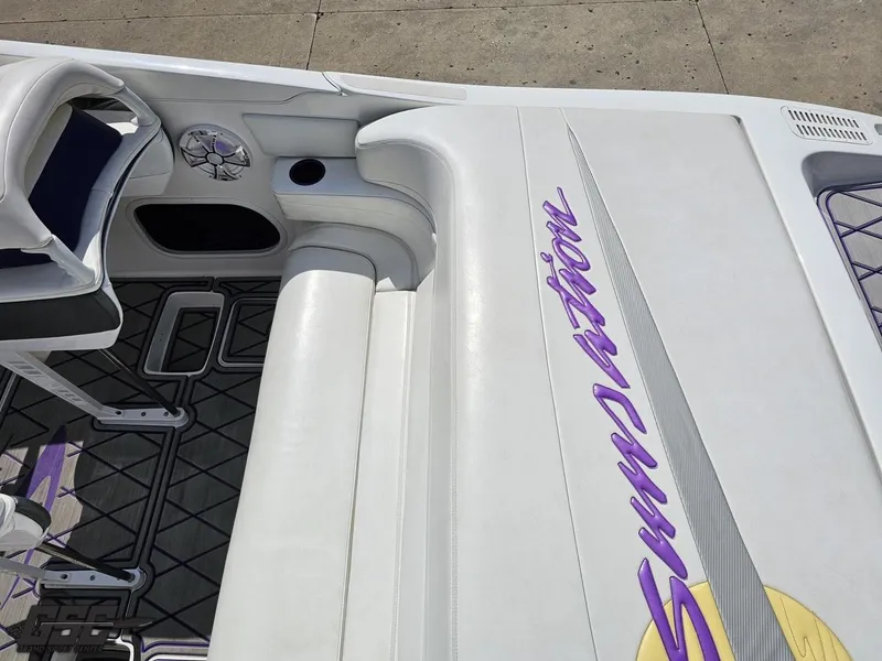 Slide: The Image of 2003 Sunsation 32 Dominator boat interior with white seating and purple logo detailing. - 49