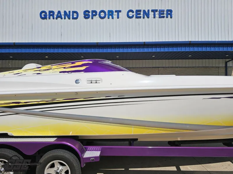 Slide: The Image of 2003 Sunsation 32 Dominator boat at Grand Sport Center, featuring vibrant purple and yellow design. - 7