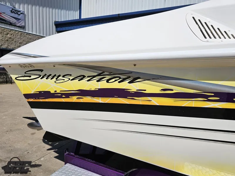 Slide: The Image of 2003 Sunsation 32 Dominator boat with vibrant yellow and purple graphics. - 9