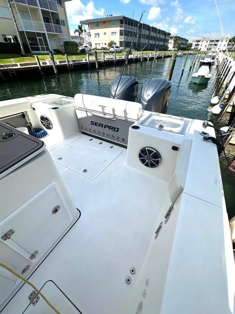 Slide: The Image of 2022 Sea Pro 320 DLX Center Console boat docked in a marina, showcasing spacious deck. - 13