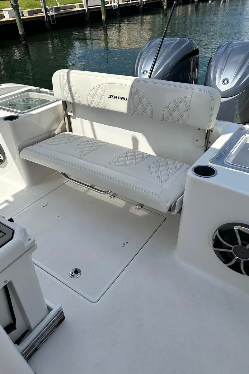 Slide: The Image of 2022 Sea Pro 320 DLX Center Console boat with cushioned seating and dual engines. - 16