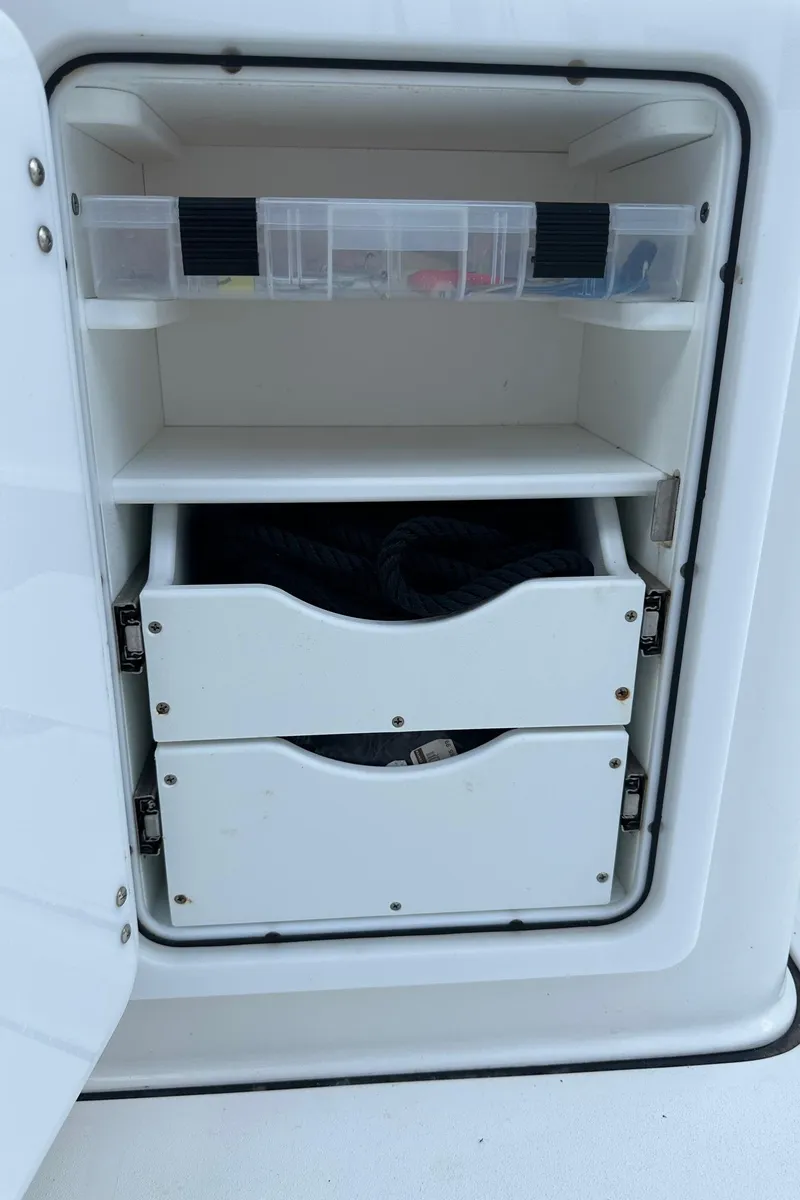 Slide: The Image of Storage compartment on a 2022 Sea Pro 320 DLX Center Console boat with shelves and drawers. - 20