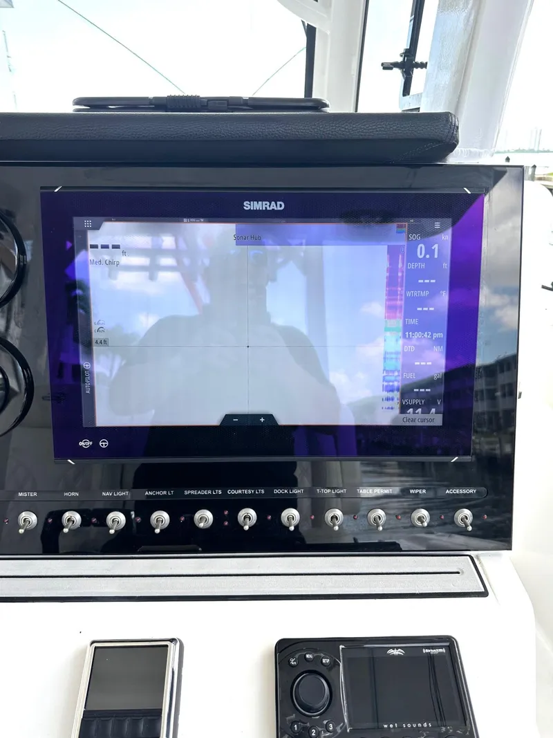 Slide: The Image of 2022 Sea Pro 320 DLX Center Console dashboard with Simrad display and controls. - 24