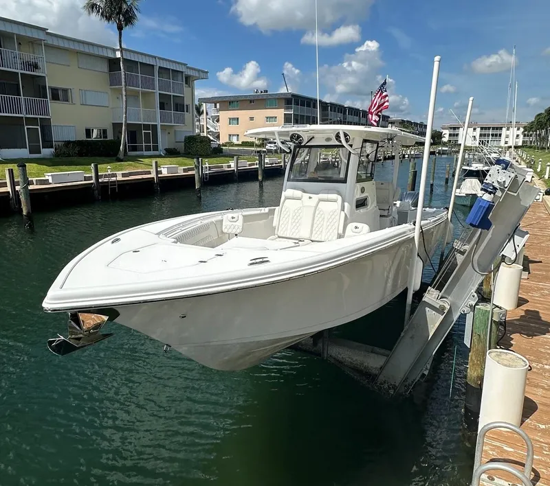 Slide: The Image of 2022 Sea Pro 320 DLX Center Console boat docked in a marina under a clear sky. - 4