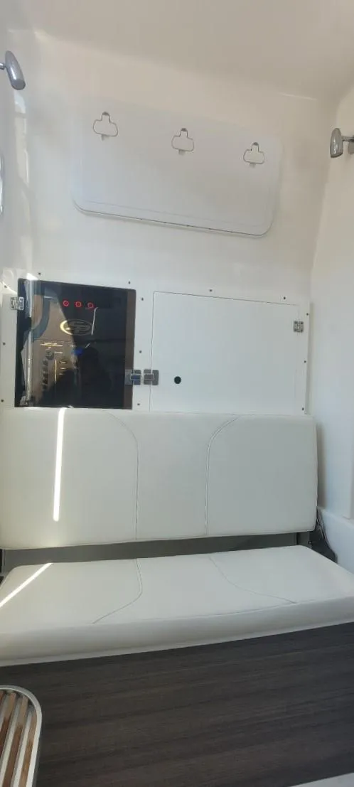 Slide: The Image of 2022 Sea Pro 320 DLX Center Console interior with white seating and storage compartments. - 40