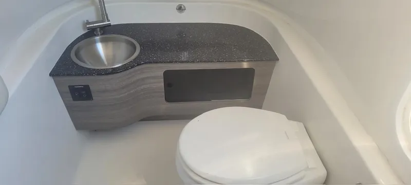 Slide: The Image of 2022 Sea Pro 320 DLX Center Console bathroom with sink and toilet. - 41