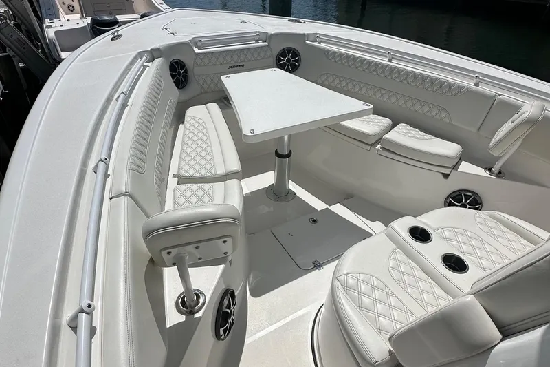 Slide: The Image of 2022 Sea Pro 320 DLX Center Console boat interior with white seating and table. - 6