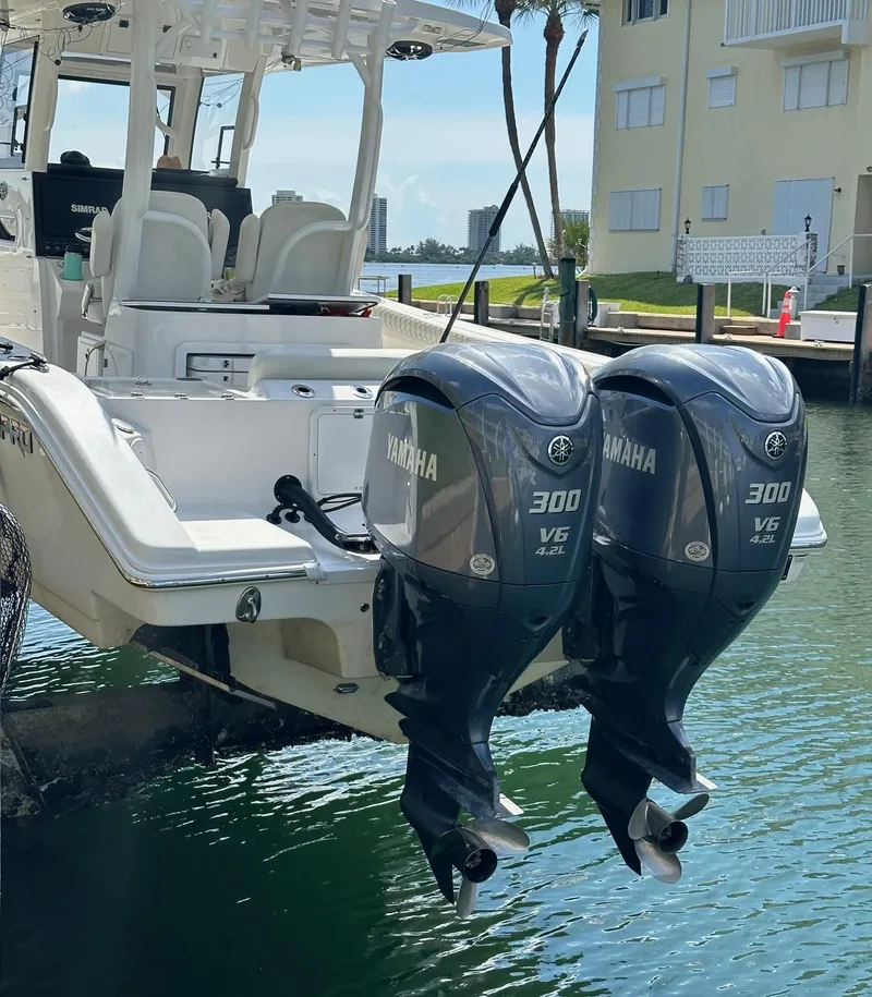 Slide: The Image of 2022 Sea Pro 320 DLX Center Console with twin Yamaha 300 engines docked by waterfront. - 9