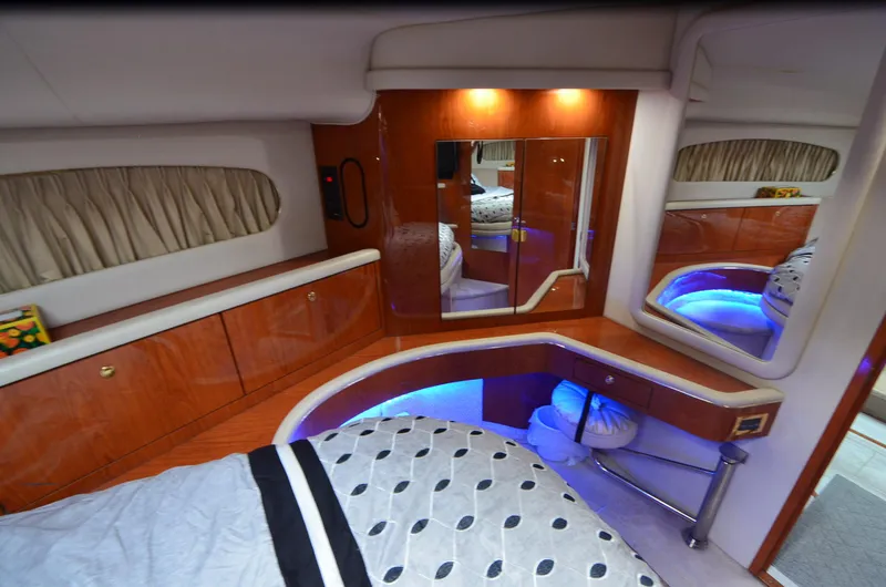 Slide: The Image of Luxurious interior of 2000 Sea Ray 420 Aft Cabin with elegant wood finish and ambient lighting. - 18