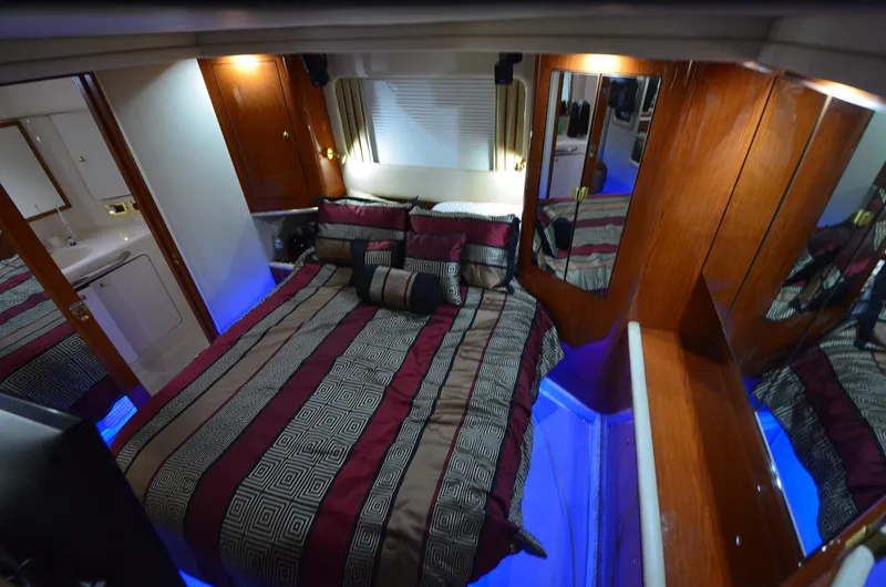 Slide: The Image of Luxurious cabin interior of 2000 Sea Ray 420 Aft Cabin with elegant bedding and ambient lighting. - 28