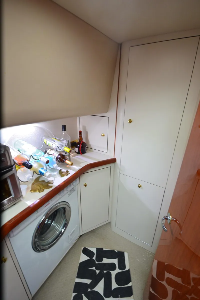 Slide: The Image of Laundry area in 2000 Sea Ray 420 Aft Cabin with washing machine and storage cabinets. - 29