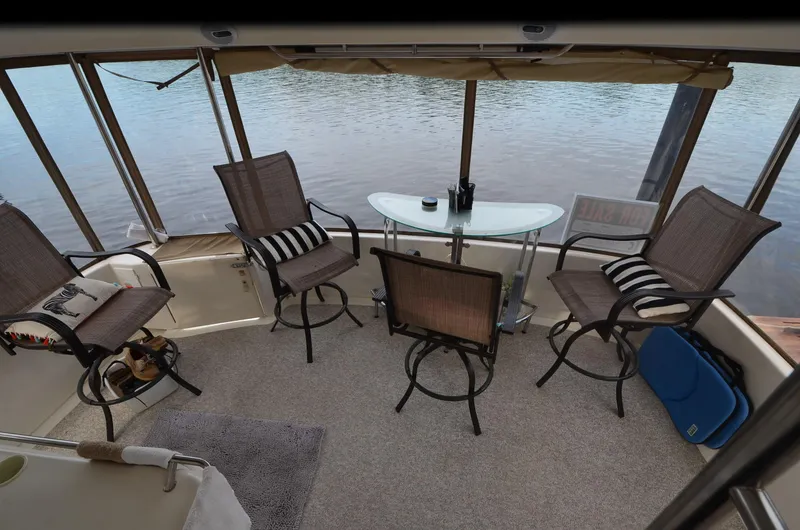 Slide: The Image of 2000 Sea Ray 420 Aft Cabin interior with chairs and table overlooking water. - 3
