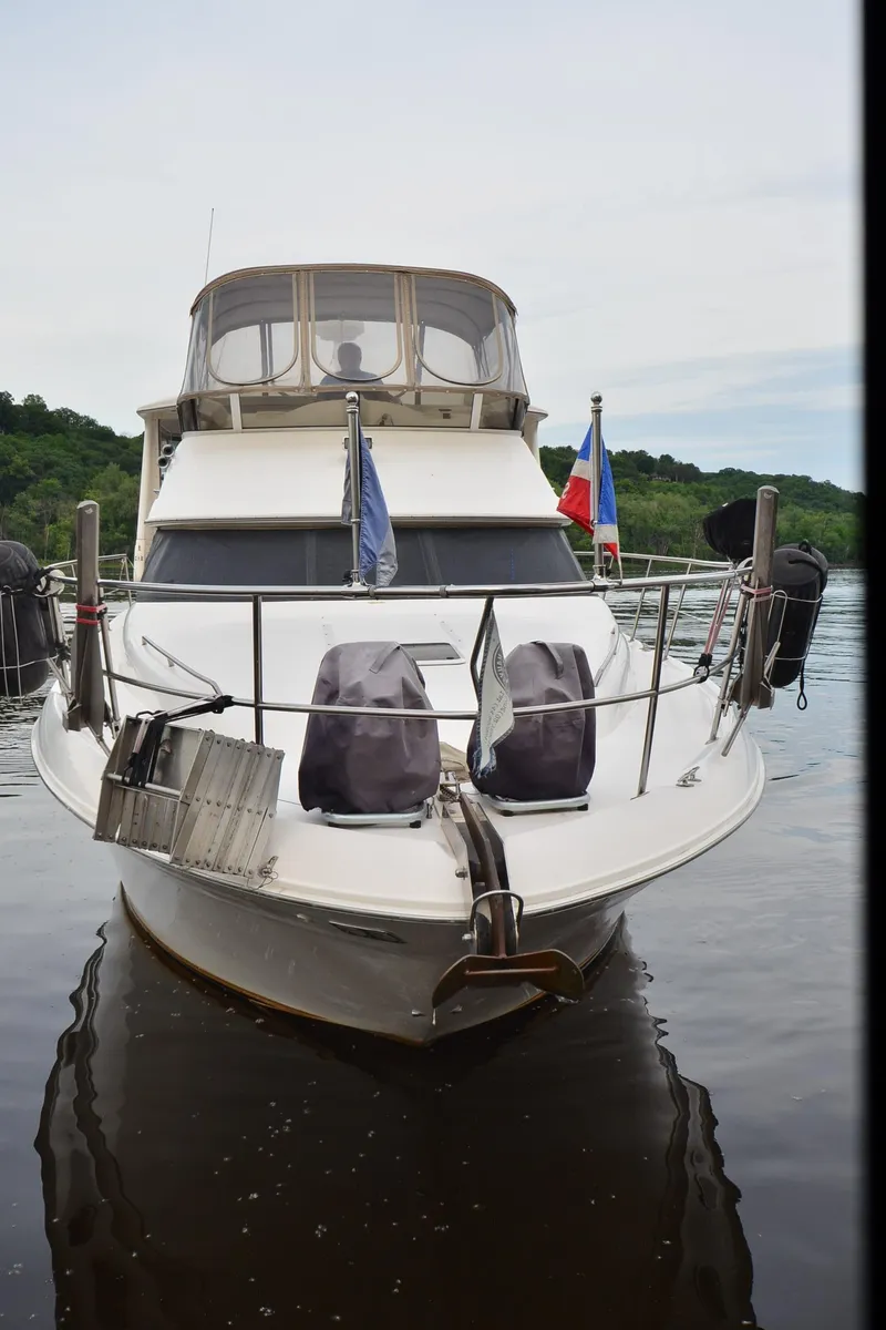 Slide: The Image of 2000 Sea Ray 420 Aft Cabin yacht docked on calm water, front view. - 46