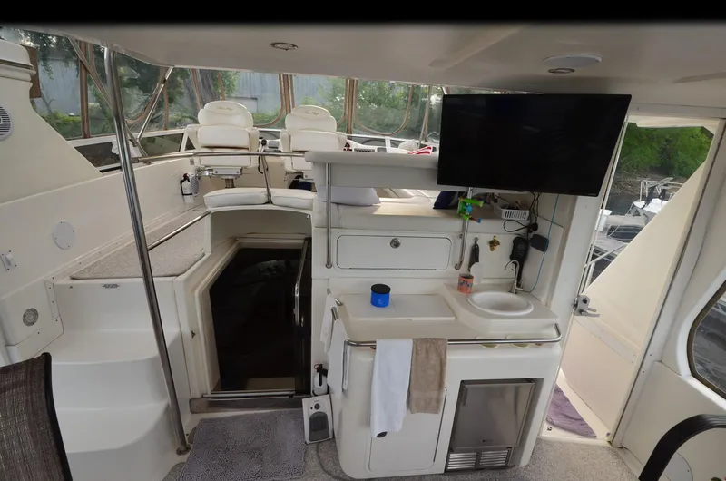 Slide: The Image of Interior of 2000 Sea Ray 420 Aft Cabin yacht with helm, seating, and kitchenette. - 7