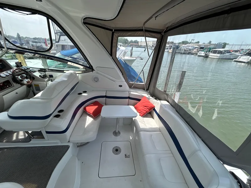 Slide: The Image of 2005 Formula 37 PC yacht interior with white seating, red cushions, and marina view. - 13