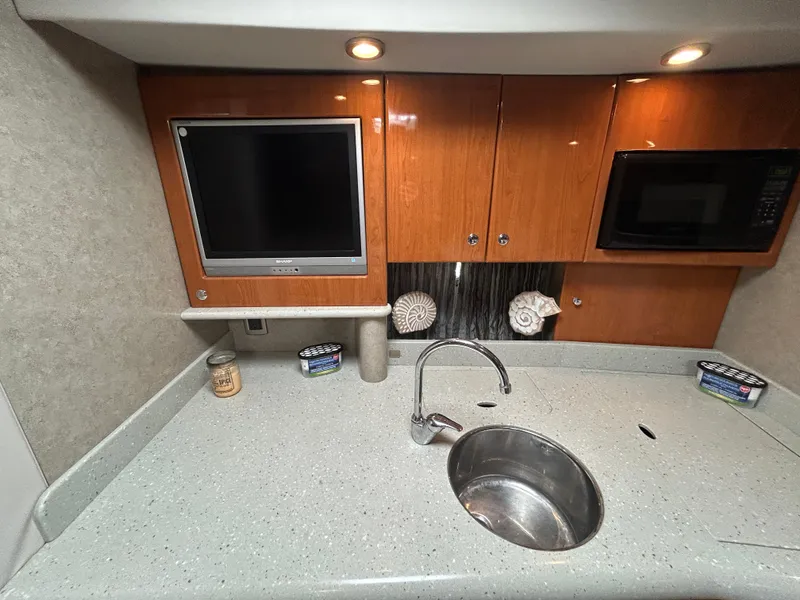 Slide: The Image of 2005 Formula 37 PC yacht kitchen with sink, TV, microwave, and wooden cabinets. - 41