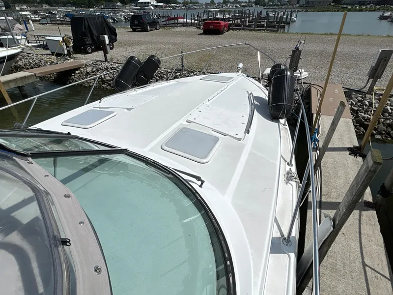 Slide: The Image of 2005 Formula 37 PC boat docked at marina, showing deck and surroundings. - 6