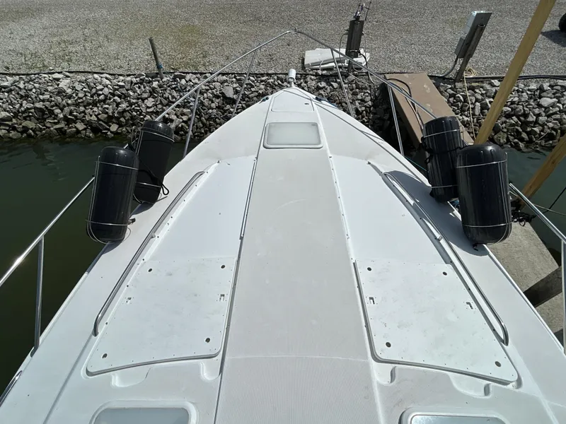 Slide: The Image of 2005 Formula 37 PC boat deck with fenders, docked by rocky shore. - 7