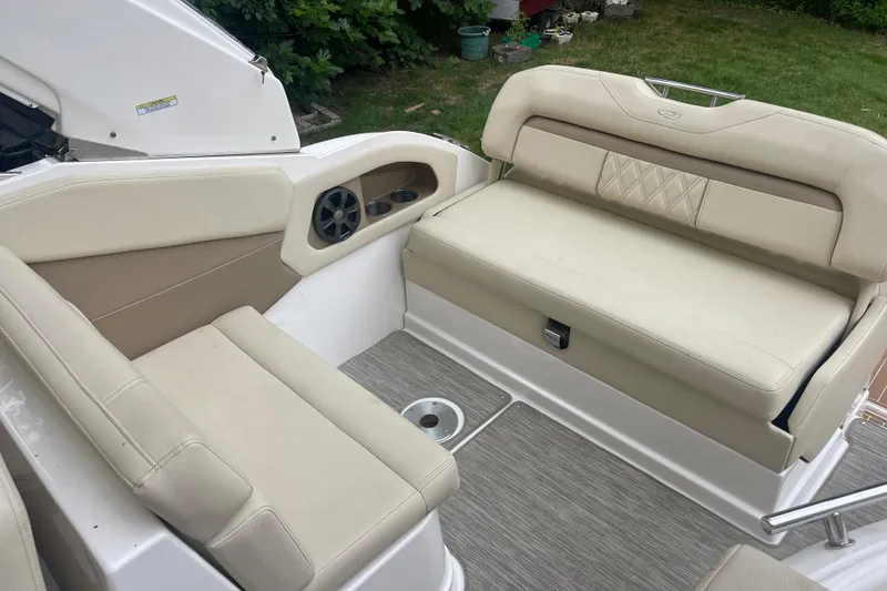 Slide: The Image of 2019 Regal 28 Express boat interior with beige seating and speaker system. - 14