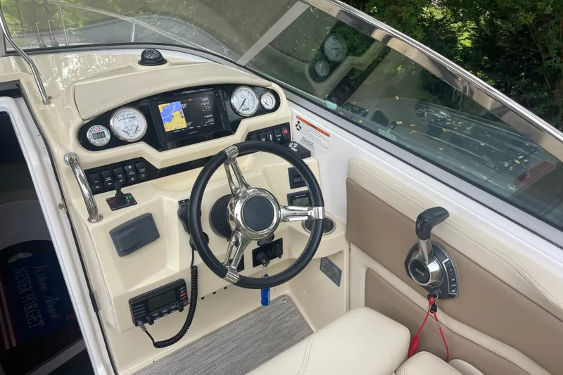 Slide: The Image of 2019 Regal 28 Express boat cockpit with steering wheel and navigation controls. - 23