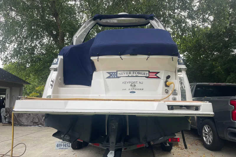 Slide: The Image of 2019 Regal 28 Express boat with "Never Forget" decal, parked in driveway. - 36
