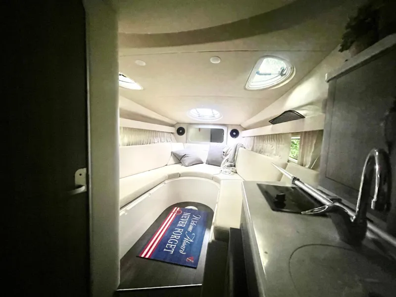 Slide: The Image of Interior of a 2019 Regal 28 Express boat, featuring a cozy cabin and kitchenette. - 4