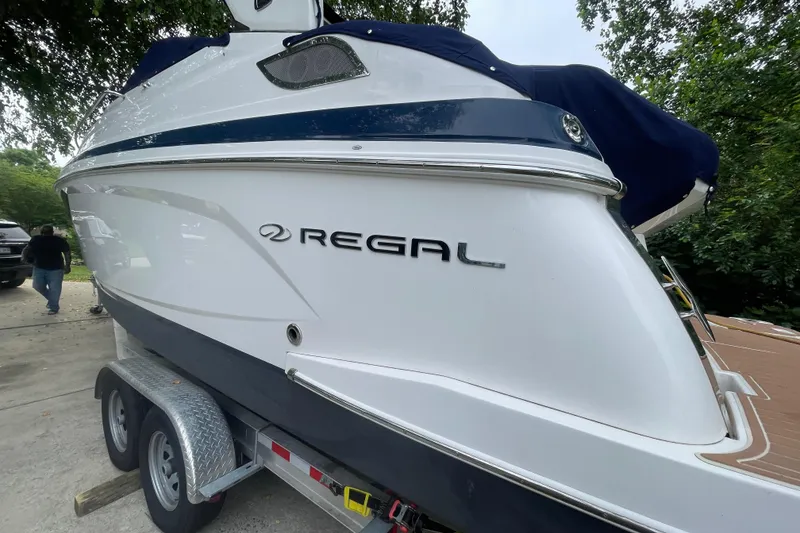 Slide: The Image of 2019 Regal 28 Express boat on trailer, side view with logo visible. - 45
