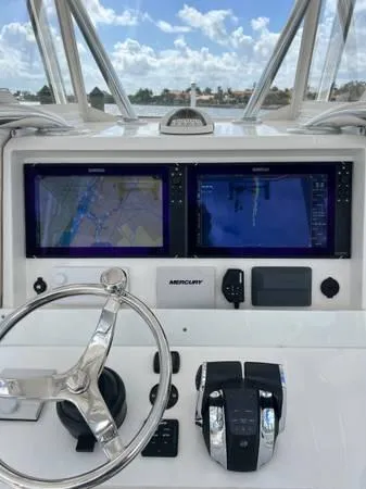 Slide: The Image of 2020 Invincible 33 Open Fisherman dashboard with dual navigation screens and steering wheel. - 3