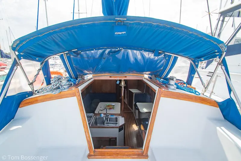 Slide: The Image of 1988 Catalina 36 sailboat interior with blue canopy, showing cabin entrance and seating area. - 10