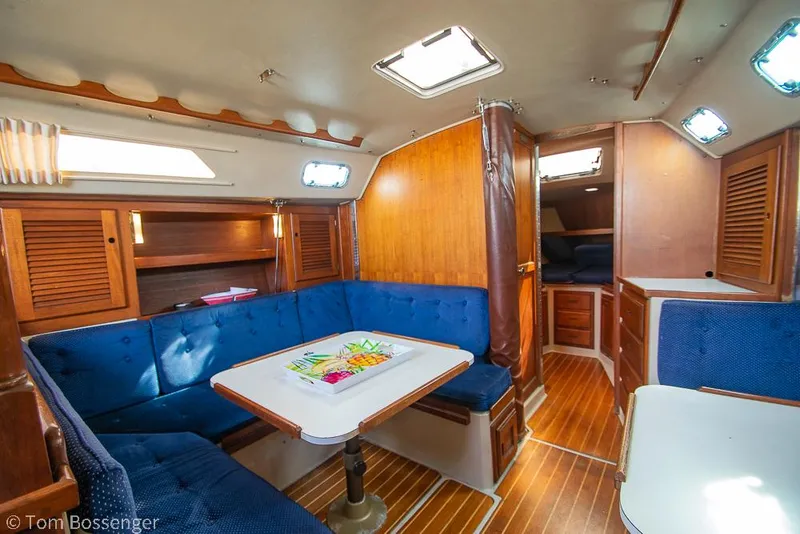 Slide: The Image of Interior of 1988 Catalina 36 sailboat with blue seating and wooden finishes. - 11