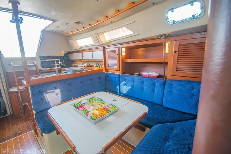 Slide: The Image of Interior of 1988 Catalina 36 sailboat with blue seating and wooden cabinetry. - 13