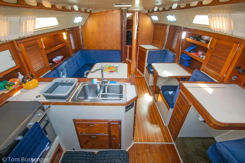 Slide: The Image of Interior of 1988 Catalina 36 sailboat with wood finish and blue seating. - 15