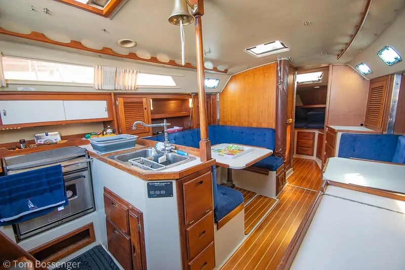 Slide: The Image of Interior of 1988 Catalina 36 sailboat with kitchen, dining area, and wood finishes. - 17