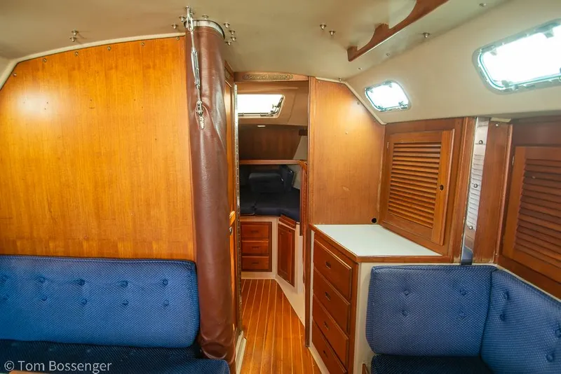Slide: The Image of Interior of 1988 Catalina 36 sailboat with wooden cabinetry and blue seating. - 21
