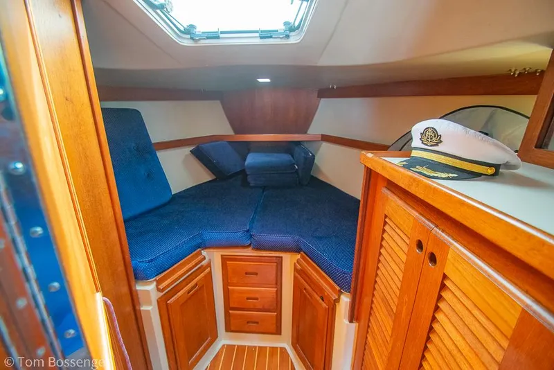 Slide: The Image of Cozy cabin interior of 1988 Catalina 36 sailboat with blue cushions and captain's hat. - 22