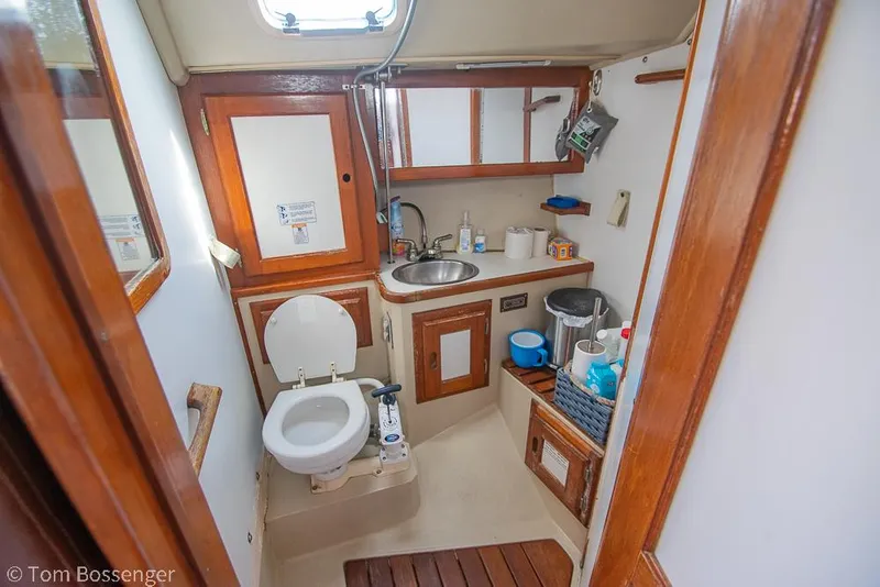 Slide: The Image of Interior of 1988 Catalina 36 sailboat bathroom with sink, toilet, and wooden cabinetry. - 23