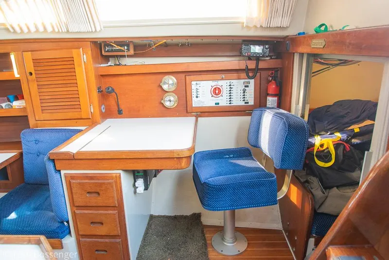 Slide: The Image of Interior of 1988 Catalina 36 sailboat with navigation station and blue seating. - 27
