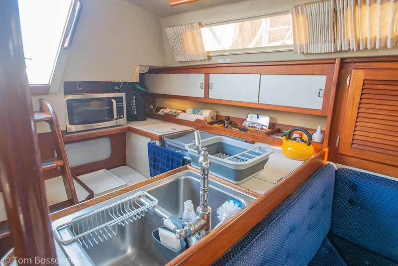 Slide: The Image of Interior of 1988 Catalina 36 sailboat kitchen with sink, microwave, and storage cabinets. - 4