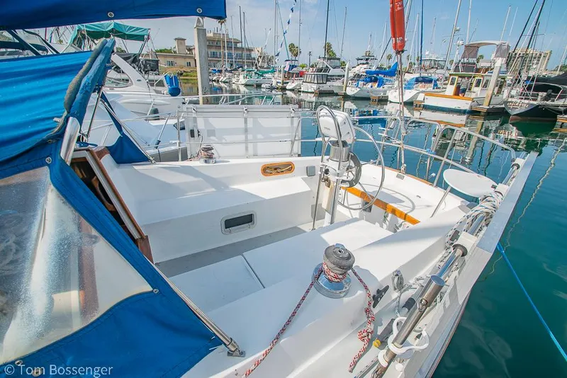 Slide: The Image of 1988 Catalina 36 sailboat docked in marina, featuring spacious cockpit and blue canopy. - 9