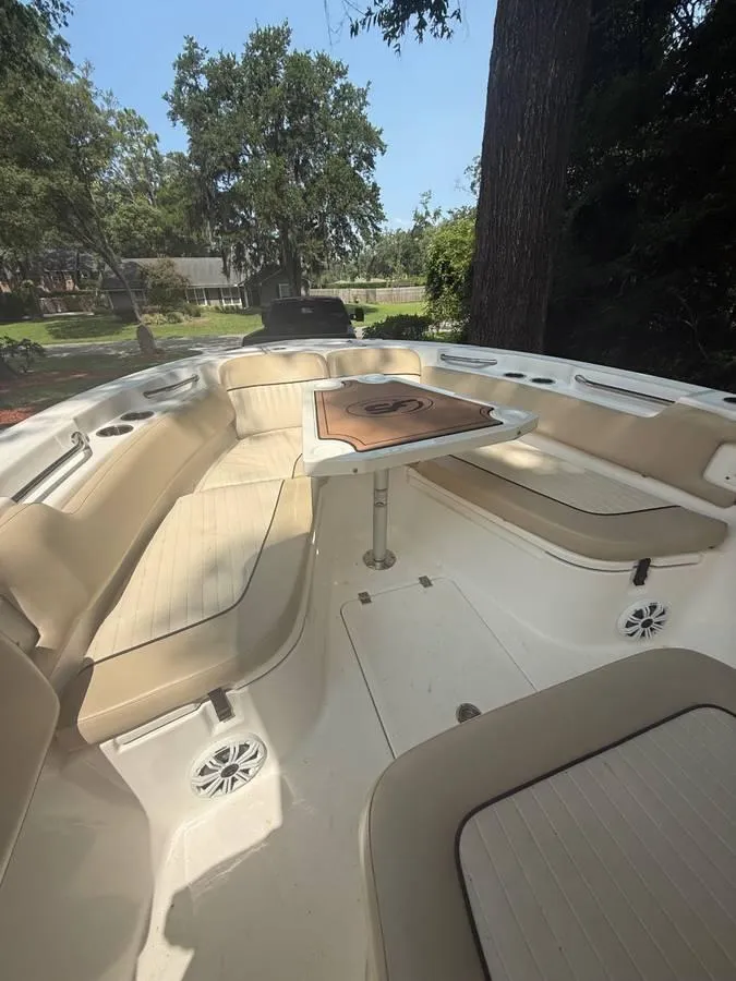 Slide: The Image of 2018 Sea Fox 248 Commander boat interior with seating and table, surrounded by trees. - 10